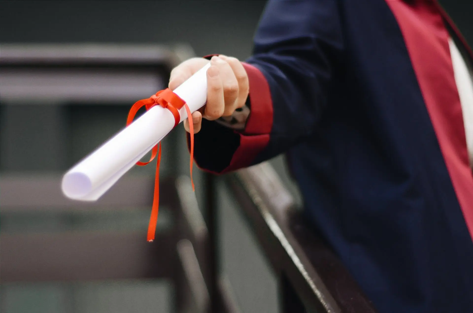 Rolled diploma being handed out to recipient.