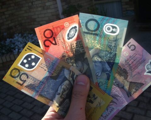 Une main tenant des dollars australiens